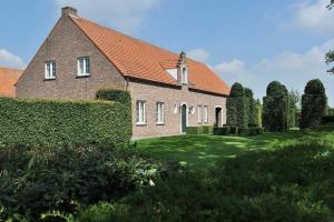 une grande maison en briques avec une cour verdoyante dans l'établissement Villa71, à Rijkevorsel