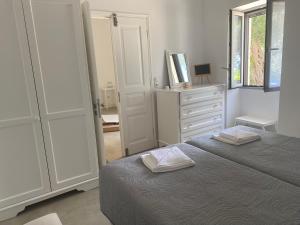 um quarto branco com uma cama e uma cómoda em Liz e mao em Vlachopoulátika