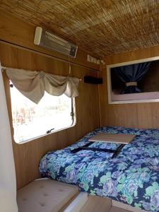 a bed in the back of an rv with a window at Le Pick up 403 vintage in Oradour-sur-Glane