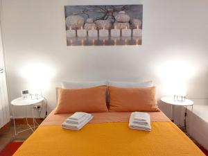 1 dormitorio con 1 cama amarilla y 2 mesas en Casa Cenzina, en Cosenza