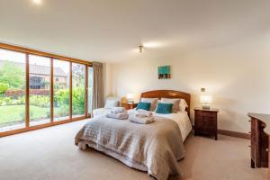 a bedroom with a bed and a large window at Owl Barn in Sculthorpe