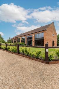 a brick building with a garden in front of it at Owl Barn in Sculthorpe