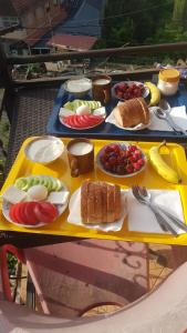 un tavolo giallo con piatti di cibo sopra di Ensol B&B a Peshkopi