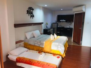 une chambre d'hôtel avec deux lits et une cuisine dans l'établissement Harmony Hotel, à Panglao
