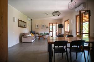 a dining room and living room with a table and chairs at Baccu Mandara Sea View Modern Villa with Parking! in Geremeas