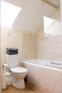 a bathroom with a toilet and a bath tub at Charming 1-Bed loft in Caerleon in Newport