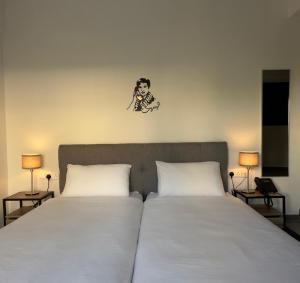 a bedroom with two beds and a clock on the wall at Zoi Ayia Napa in Ayia Napa