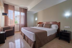 um quarto com uma cama grande e uma janela em Crisol Jardines de Córdoba em Córdoba
