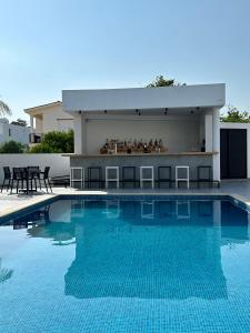 a swimming pool with a bar next to a building at Zoi Ayia Napa in Ayia Napa +27 photos