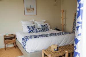 um quarto com uma cama grande com lençóis azuis e brancos em Hôtel Le Noirmoutier em Barbâtre