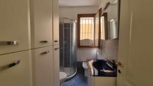 a bathroom with a sink and a toilet and a window at Appartamento Blu Relax in Capoliveri +17 photos