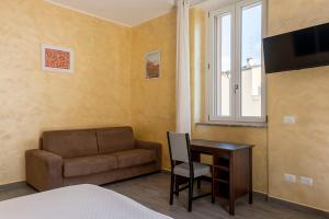 um quarto com uma cama, uma secretária e um sofá em Leader Apartment 3 em Milão