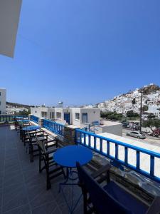 a row of tables and chairs on the roof of a building at Project Town in Ios Chora