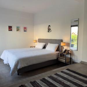 a bedroom with a bed with two lamps and a window at Zoi Ayia Napa in Ayia Napa