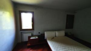 - une petite chambre avec un lit et une fenêtre dans l'établissement Villa Contea, à Scorzè