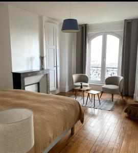 a bedroom with a bed and a living room with a fireplace at La Côte in Granville