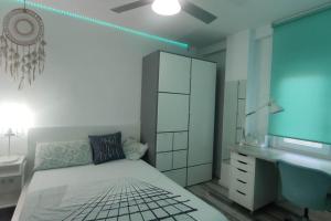 a bedroom with a bed and a bathroom with a sink at Apartamento Turquesa in Zaragoza