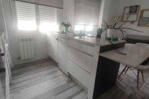 a white kitchen with a desk and a table at Apartamento Turquesa in Zaragoza +24 photos