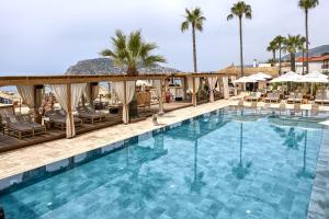 - une piscine dans un complexe avec des chaises et des parasols dans l'établissement Day One Beach Resort & SPA - Adult Only, à Alanya