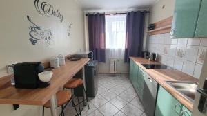 a kitchen with green cabinets and a wooden counter top at Apartament na Błoniach in Sanok