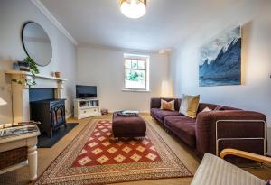 a living room with a couch and a fireplace at Old Whisky Distillery Apartment in Fort William