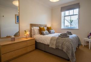 a bedroom with a bed with a dresser and a mirror at Old Whisky Distillery Apartment in Fort William