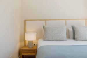 a bedroom with a bed and a lamp on a night stand at Casa Las Palmeras in Marbella