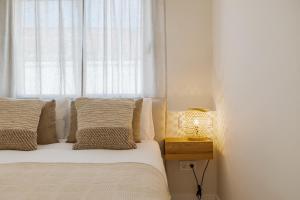 a bedroom with a bed with a window and a lamp at Casa Las Palmeras in Marbella