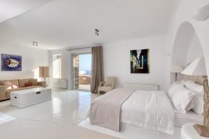 a white bedroom with a bed and a living room at Villa Ainar in Tinos +156 photos