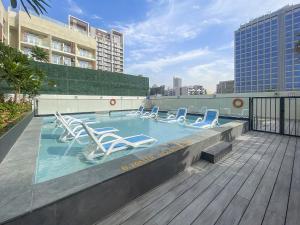 einen Pool mit Liegestühlen auf einem Gebäude in der Unterkunft A Living Luxury Studio Nicholas Residence JVC in Dubai