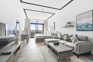 ein Wohnzimmer mit einem Sofa und einem Tisch in der Unterkunft A Living Luxury Studio Nicholas Residence JVC in Dubai