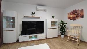 a living room with a flat screen tv and a chair at Vista Capodistria in Koper