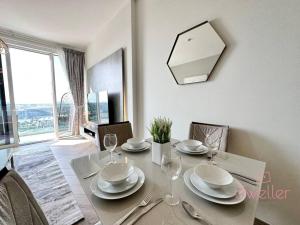 ein Esszimmer mit einem Tisch mit Tellern und Weingläsern in der Unterkunft Dweller - Luxury Apartment Sleep 4 in Dubai