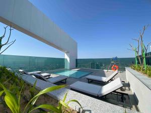 une maison en verre avec une piscine et des chaises longues dans l'établissement Dweller - Luxury Apartment Sleep 4, à Dubaï
