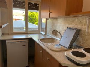 a kitchen with a sink and a tablet on a counter at Villa Maria Petru in Ierissos