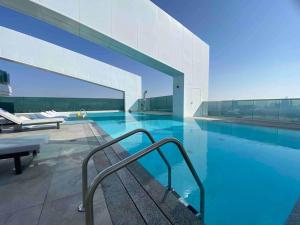ein Pool in einem Gebäude mit blauem Wasser in der Unterkunft Dweller - Luxury Apartment Sleep 4 in Dubai