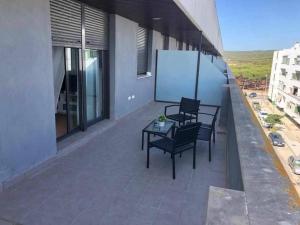 een balkon met 2 stoelen en een tafel op een gebouw bij Camarote 303 in Barbate