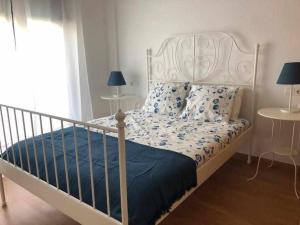 um quarto com uma cama branca e um edredão azul em Camarote 303 em Barbate