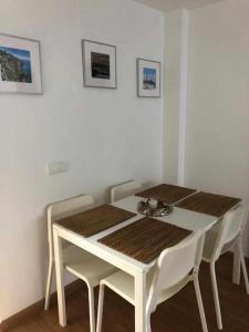 una mesa blanca con sillas blancas, una mesa blanca, una mesa y un sillón en Camarote 303, en Barbate