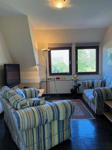 a living room with two couches and a television at EUT-IN Hotel Alte Straßenmeisterei in Eutin