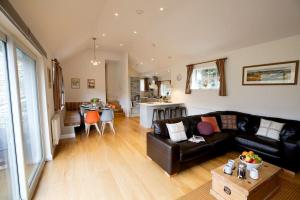 a living room with a black couch and a kitchen at Langdale Cottage - 5 bedrooms and 5 bathrooms in Chapel Stile