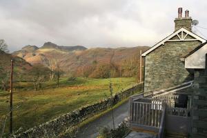a house with a view of a field and mountains at Langdale Cottage - 5 bedrooms and 5 bathrooms in Chapel Stile