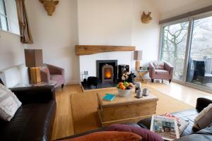 sala de estar con sofá y chimenea en Langdale Cottage - 5 bedrooms and 5 bathrooms en Chapel Stile