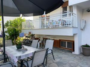 a patio with a table and chairs and an umbrella at Villa Maria Petru in Ierissos