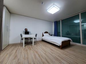 済州市にあるSky Oreum Pensionのベッドルーム1室(ベッド1台、ノートパソコン付きのテーブル付)