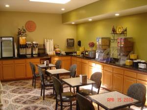 a restaurant with tables and chairs and a counter at Days Inn by Wyndham Carlsbad in Carlsbad