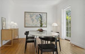 a dining room with a white table and chairs at Beautiful Home In Idestrup With Wifi And 3 Bedrooms in Idestrup