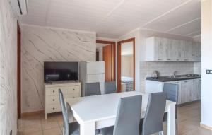 cocina y comedor con mesa blanca y sillas en Nice Apartment In Tronca With 2 Bedrooms And Wifi, en Marina di Strongoli