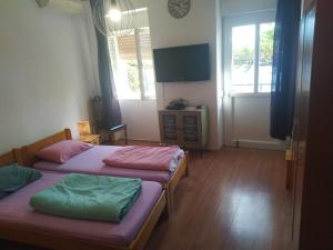 a bedroom with two beds and a tv on the wall at Apartment Doris in Rijeka