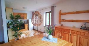 a kitchen with a wooden table and a chandelier at Villa Meledrio in Dimaro